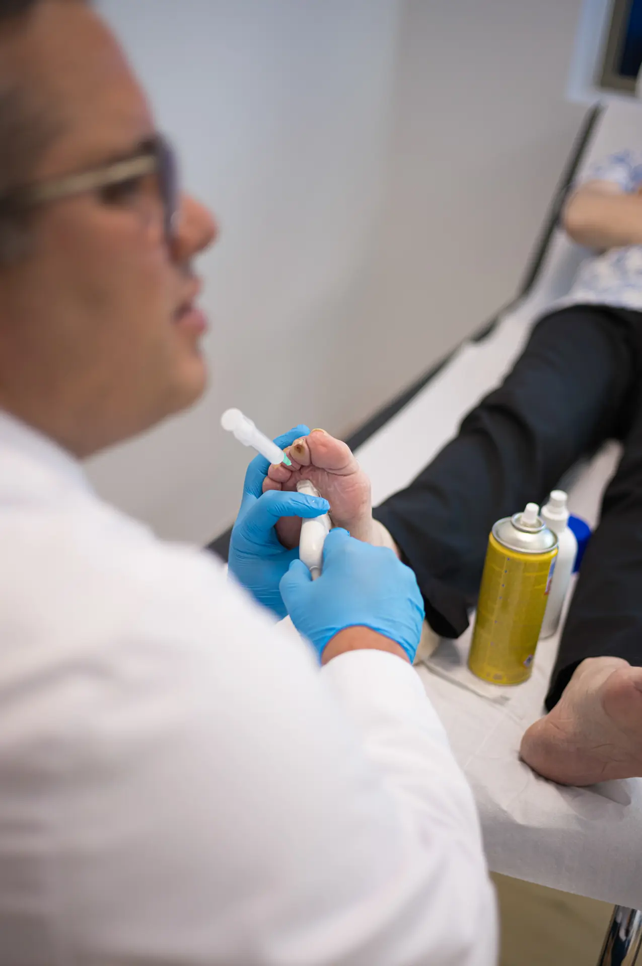 Preparación de una infiltración en la camilla de consulta, con el pie del paciente apoyado — Traumatología Mugisalud Bilbao